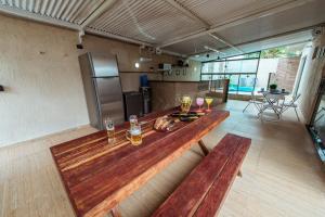 a large room with a wooden table and two benches at Casa em Jacuma, com piscina, 5 suites e fliperama in Jacumã
