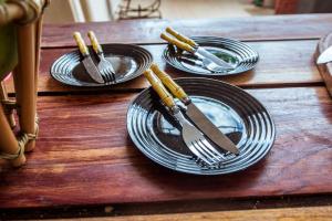 a wooden table with plates and forks and knives at Casa em Jacuma, com piscina, 5 suites e fliperama in Jacumã +34 photos