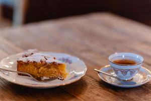 a piece of cake on a plate next to a cup of tea at Radicata Tuscany Relais in Albinia