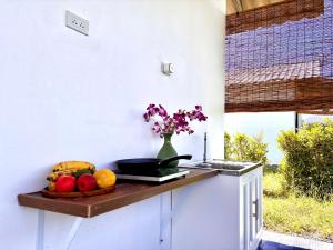 a kitchen counter with a bowl of fruit and a vase of flowers at Lalaland in Chiang Dao +17 photos