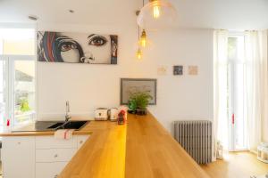 a kitchen with a wooden floor and a painting on the wall at Très beau et grand T2, jardin et terrasse in Biarritz