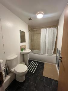 Stylish 2 bed Duplex Apartment - Birmingham في برمنغهام: حمام مع مرحاض ومغسلة وحوض استحمام