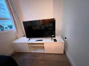 Stylish 2 bed Duplex Apartment - Birmingham في برمنغهام: تلفزيون على خزانة بيضاء في غرفة