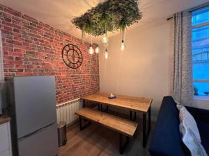 Stylish 2 bed Duplex Apartment - Birmingham في برمنغهام: مطبخ مع طاولة وجدار من الطوب +12 صورة