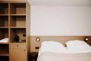 ein Schlafzimmer mit einem weißen Bett und Holzregalen in der Unterkunft Bryggjan Boutique Hotel in Akureyri