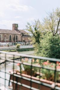 ヴィチェンツァにあるPalladio Apartment - Vista Fiume, In Centro con Garageの花の咲くバルコニーから建物の景色を望めます。