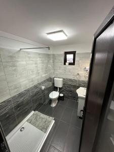 une salle de bain avec une douche, des toilettes et un lavabo dans l'établissement LRMS Sport Club, 