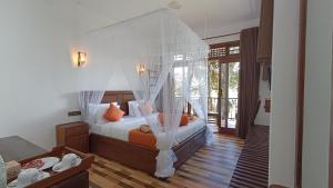 a bedroom with a bed with a canopy at Ameliora Hotel Ella in Ella