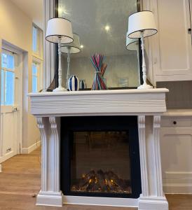 - une cheminée avec deux lampes au-dessus dans l'établissement Charmant appartement en centre-ville, à Le Touquet-Paris-Plage