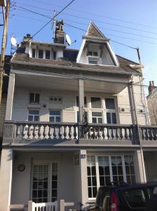 une maison blanche avec un balcon dans une rue dans l'établissement Charmant appartement en centre-ville, à Le Touquet-Paris-Plage