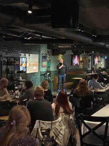 a man giving a presentation in a room with people at Bardufoss Hotell in Bardufoss