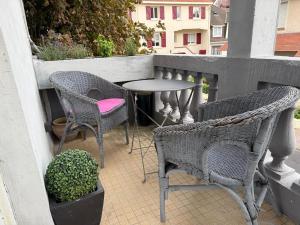 un patio avec deux chaises et une table sur un balcon dans l'établissement Charmant appartement en centre-ville, à Le Touquet-Paris-Plage 6 autres photos