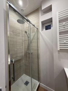 une douche avec une porte vitrée dans une salle de bain dans l'établissement Charmant appartement en centre-ville, à Le Touquet-Paris-Plage