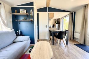 un salon avec un canapé et une table dans l'établissement Bungalow & caravane vintage proche plages, à Ploemeur