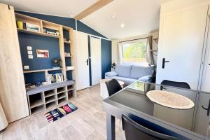 un salon avec une table et un canapé dans l'établissement Bungalow & caravane vintage proche plages, à Ploemeur 32 autres photos