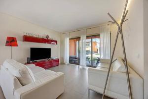 een woonkamer met een witte bank en een tv bij Orange Lux Villa 3I in Luz de Tavira