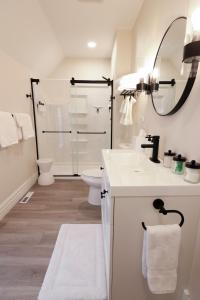 a white bathroom with a shower and a sink at Eliza Gothic in Maquoketa