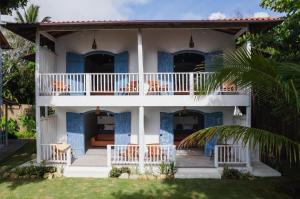 a villa with a balcony and chairs in the yard at Villa Maree Bahia in Marau