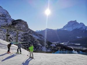 a group of three people on a snow covered ski slope at Residence Peniè in San Vito di Cadore
