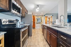 a kitchen with wooden cabinets and stainless steel appliances at Copperheads 14th Hole Suite in Lake Shore Estates