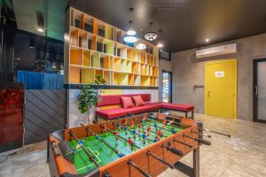a room with a foosball table and a couch at Patong Poshtel in Patong Beach