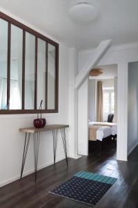 Habitación blanca con cama y mesa con manzana. en Les Toits de Chartres - 2 appt - Parking gratuit, en Chartres