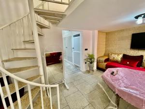 a living room with a spiral staircase and a red couch at Luxury apartment Fes centre ville - Family & Friendly in Oulad Akkou