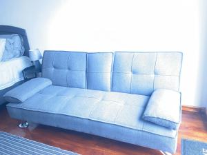 a blue couch in a living room next to a bed at Jo-Anne Villa #Jeffreys Bay in Jeffreys Bay