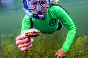 a person with a snorkel and a shell in their hand at Copperheads 14th Hole in One! in Lake Shore Estates