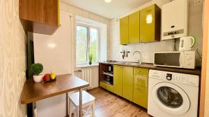 a kitchen with a washer and a washing machine at Botanical garden area in Kharkiv