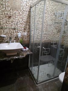 a bathroom with a glass shower and a sink at South B Paradise in Cairo