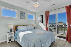 a bedroom with a bed and a balcony at Walk to everything, 360 views, elevator, fence in Surf City