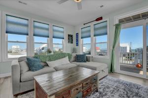 a living room with a couch and a table at Walk to everything, 360 views, elevator, fence in Surf City