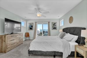 a bedroom with a bed and a flat screen tv at Walk to everything, 360 views, elevator, fence in Surf City