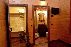 baño de madera con aseo y TV en Xilino Horio, en Chrysomiléa