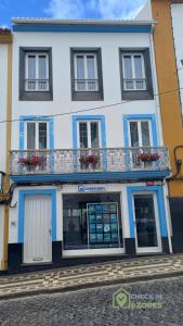 a blue and white building with a balcony at Terraço e vista deslumbrante no centro de Angra in Angra do Heroísmo