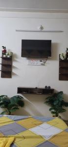 a living room with a flat screen tv on a wall at Easy Stay in Tiruvannāmalai