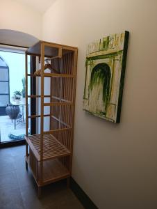 a wooden book shelf next to a wall with a painting at Casa de Solís in Trujillo