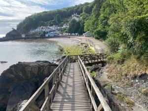 a wooden bridge over a beach next to the water at Cosy cottage in Torquay