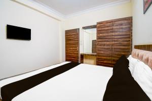 ein Schlafzimmer mit großem Bett und Fernseher in der Unterkunft OYO Flagship hotel vasundhara inn in Lucknow