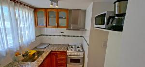 a small kitchen with a stove and a microwave at Apartamento exclusivo con ubicación preferencial in La Plata +10 photos