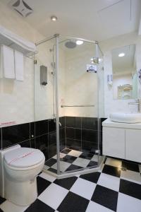 uma casa de banho com um chuveiro, um WC e um lavatório. em Morwing Hotel Fuzhong em Taipei