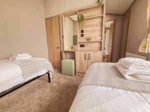バセンスウェイトにあるHornbeam Lodgeのベッド2台と鏡のある寝室
