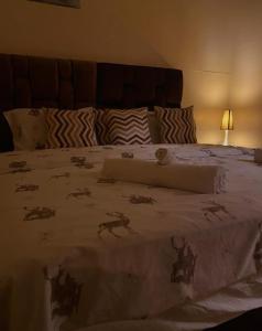 a bed with a blanket with animals on it at guyville house in Temara