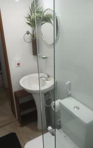 a bathroom with a sink and a mirror and a toilet at Suíte Cambury in São Sebastião