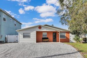 タンパにあるroomstr Alaska Room 1 Bedroom near MacDill AFB with Shared Full Bathroom includes FREE COFFEEの車道に椅子が置かれた白とオレンジ色の家