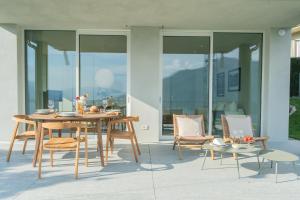 una mesa y sillas en un patio con puertas de cristal en Valarin Elite Lake Villa by Rentallcomo, en Vercana