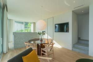 una sala de estar con una mesa y un sofá en Valarin Elite Lake Villa by Rentallcomo, en Vercana