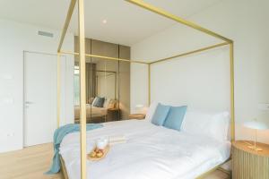 1 dormitorio con 1 cama blanca con dosel de metal en Valarin Elite Lake Villa by Rentallcomo, en Vercana