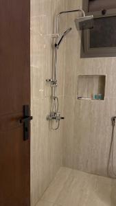 a shower with a shower head in a bathroom at شقق ضيافة البرج in Al Kharj